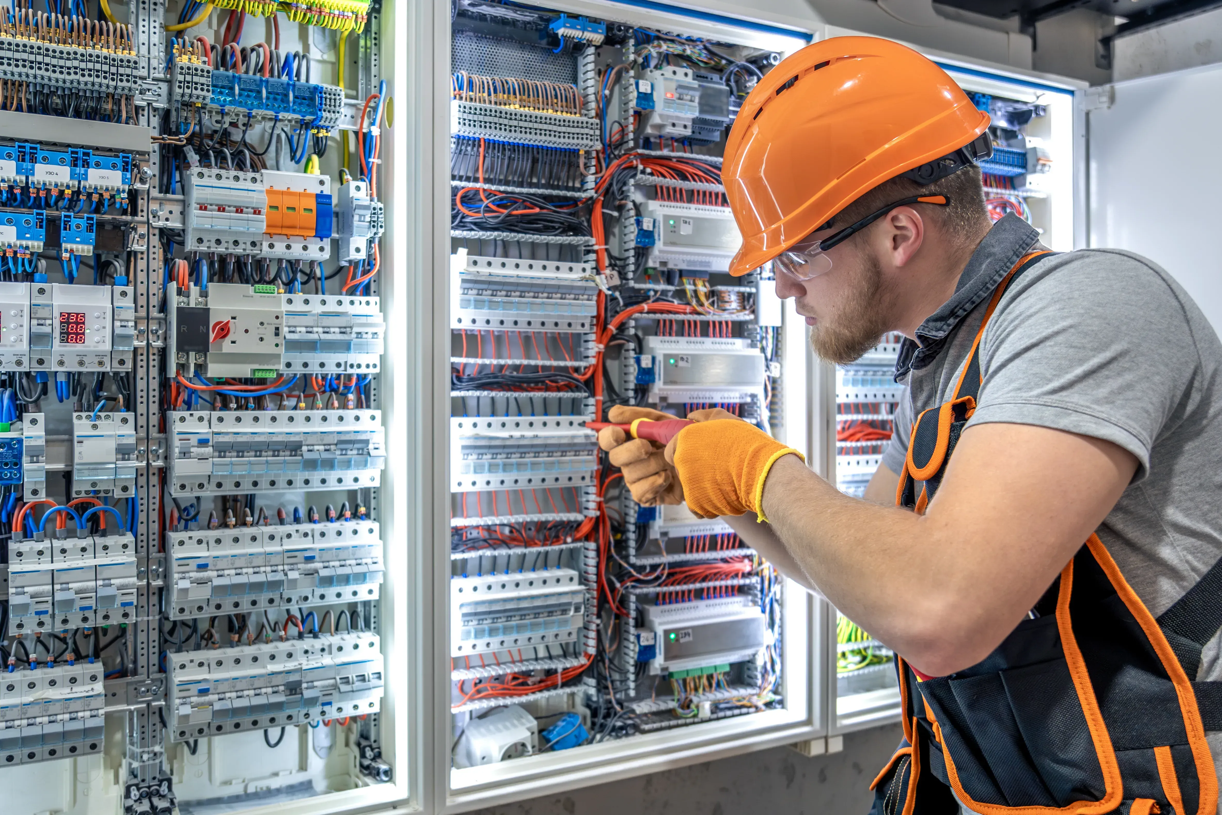 Baugruppenmontage für Gebäudeautomation, ein Handwerker arbeitet an der Gebäudetechnik