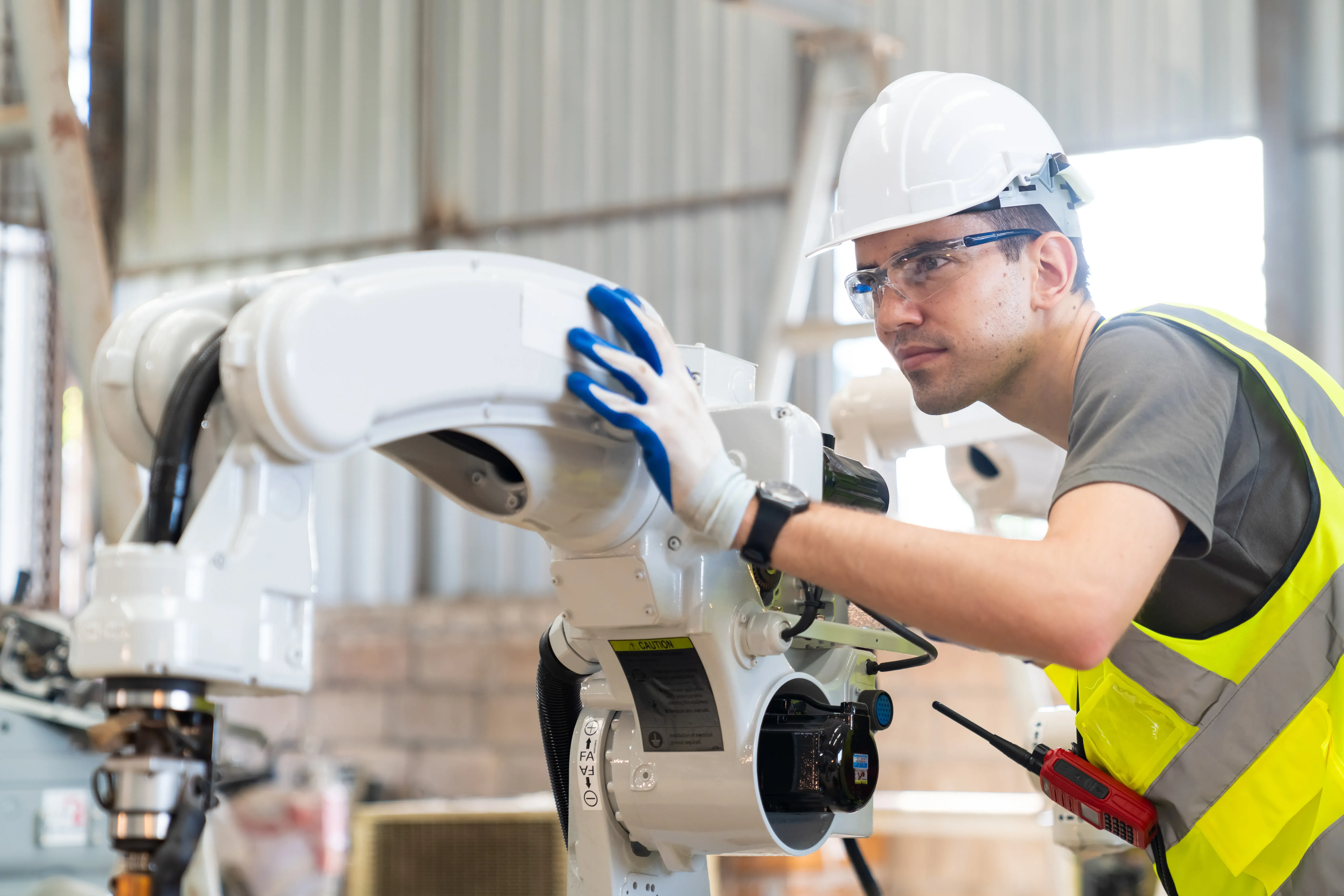 Kabelkonfektion für Maschinenbau und Industrie. Ein Techniker arbeitet an einem Industrieroboter in der Produktion
